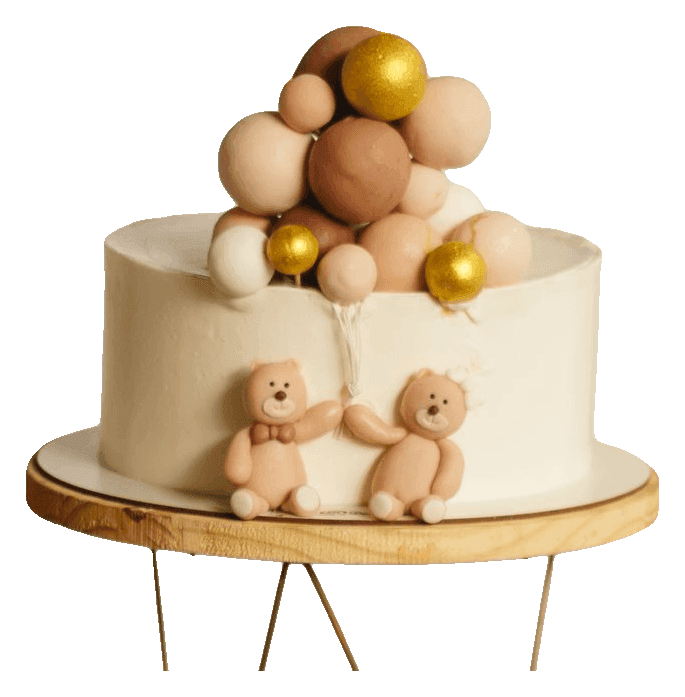 White baby shower cake with teddy bears and a cluster of cream and gold balls on a cake stand